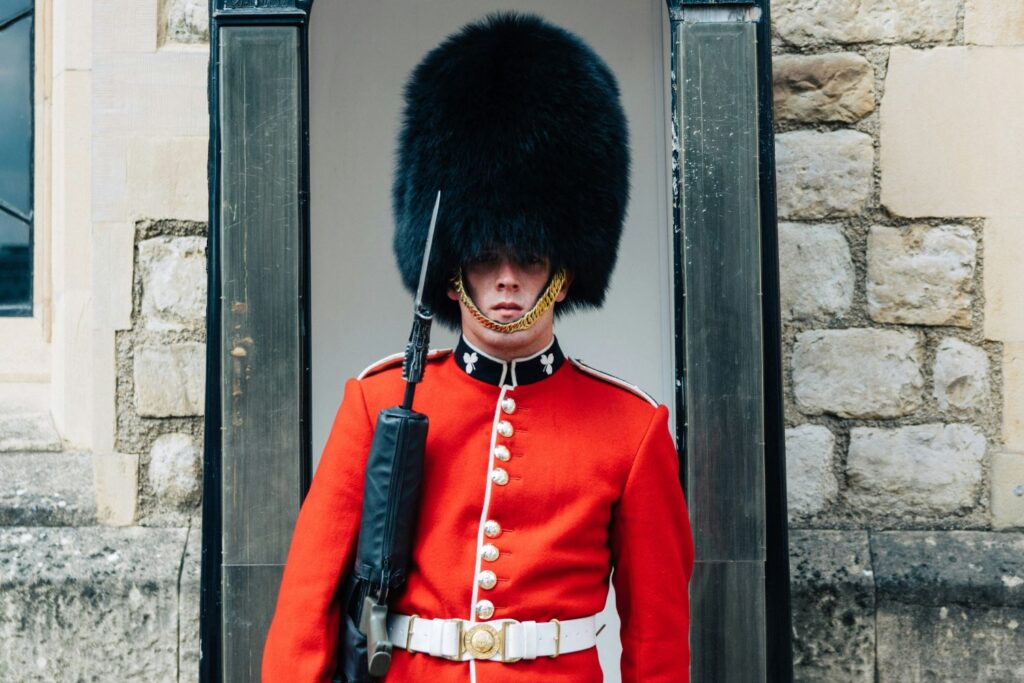 British soldier in red coat and tall hat standing guard in guard box